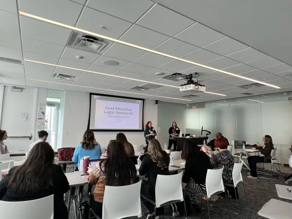 Photo of presenters speaking to group at the conference.