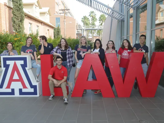 Students posing around A LAW large letters 