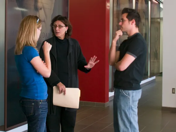 Two women and a man chatting in the lobby of the law school