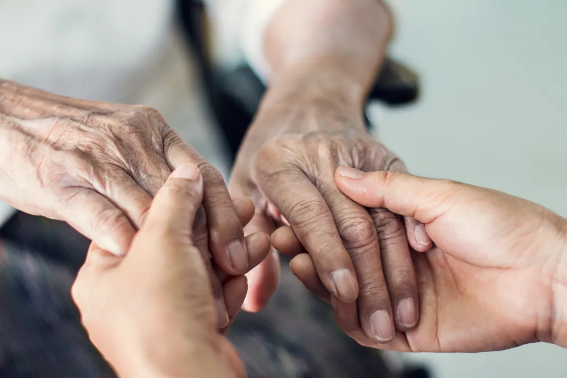 elderly hands holding younger hands for assistance