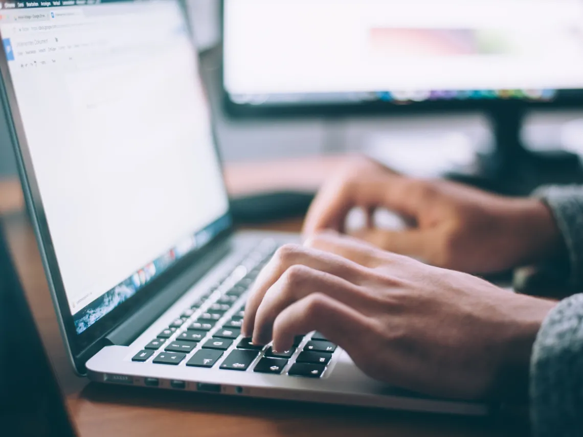 open computer with hands typing 